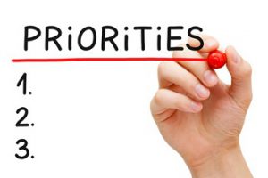 Hand writing Priorities list with marker isolated on white.
