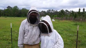 Mandy in beekeeper outfit with East Hill Honey Owner Tommy Van Horn