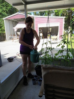 Mandy watering plants on her back porch.